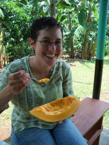 Ana eating one of Anthony's papayas at his farm